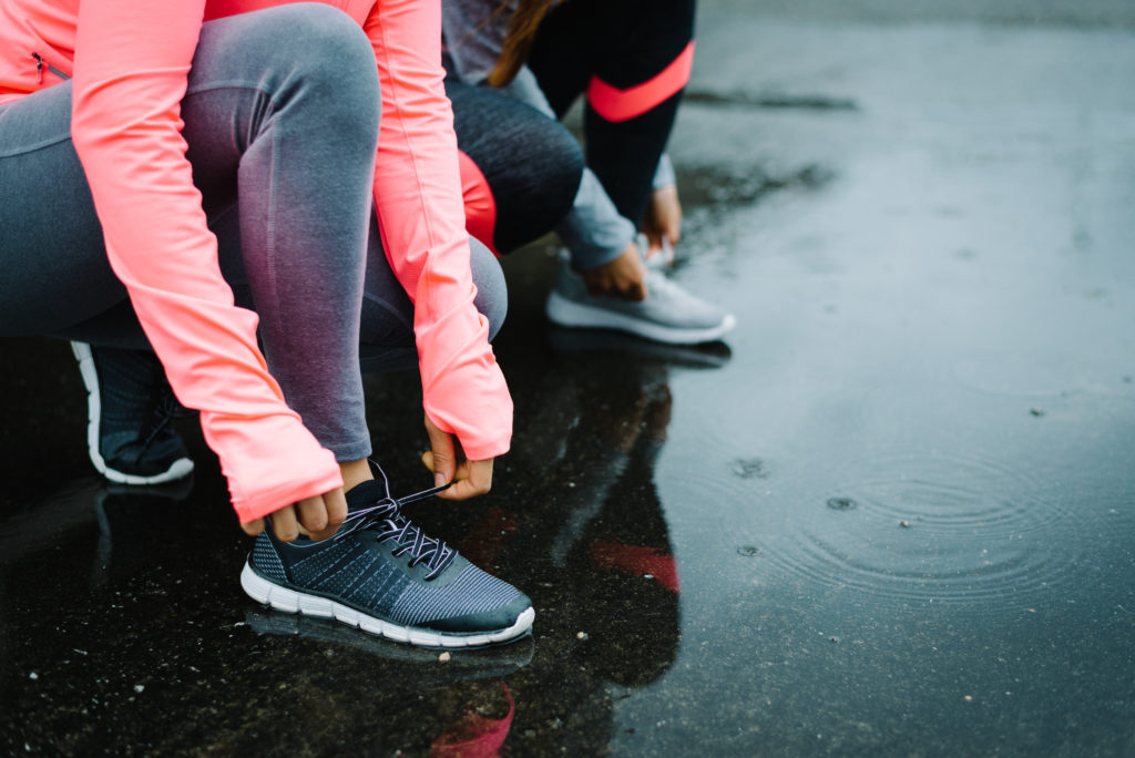 Runners are tying their shoe laces in the rain.  Should you run in the rain if sick?