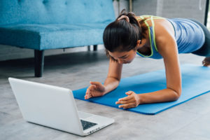 Woman exercising with a personal trainer on the computer
