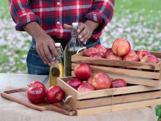 Apple Cider Vinegar (ACV) is another common kitchen ingredient.  Man with apple cider and apples. 