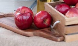 Red apples on a cutting board and in a box.
