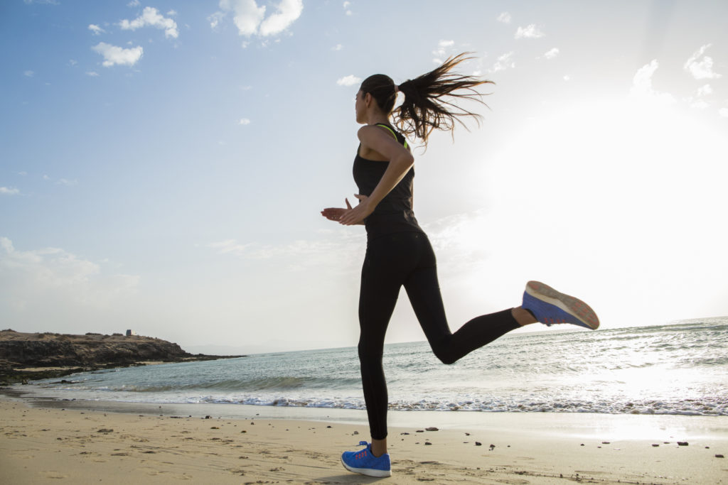 Sport is healthy! Train whenever you can. - woman running on the beach using the energy she has 