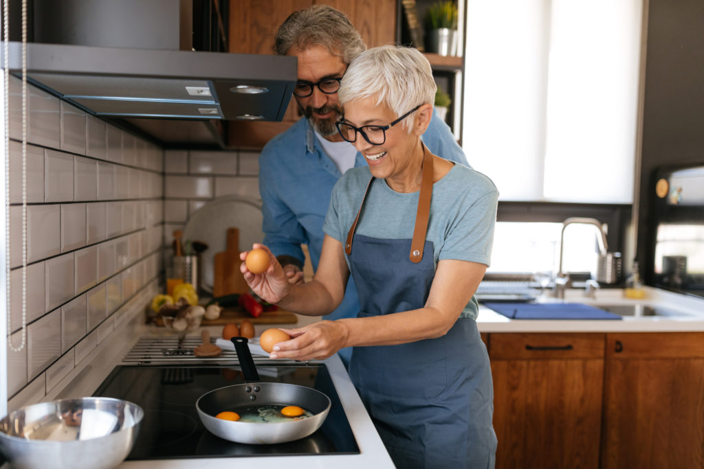 Happy mature couple preparing a meal together at home