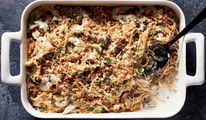 Chicken Tetrazzini in a baking dish with one serving removed. 