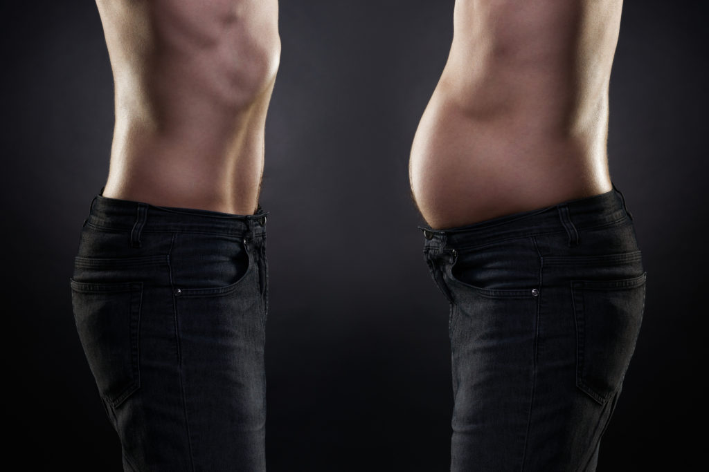 Man before and after weight loss. Fat and slim body on black background.  Had a pot belly before but otherwise fit looking. 