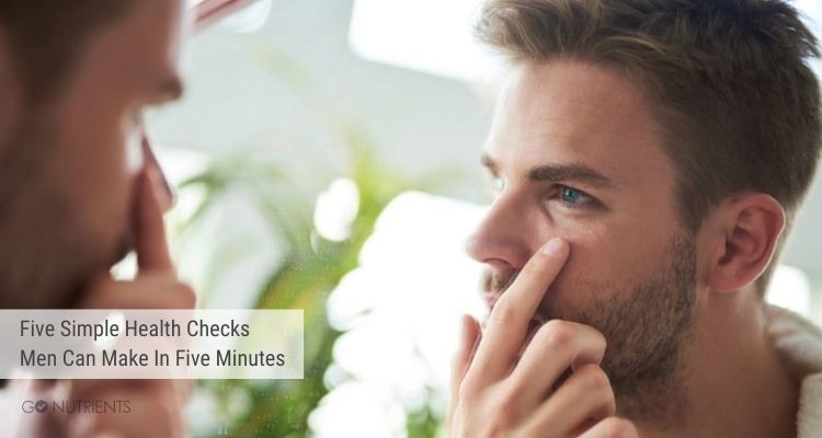 Five Simple Health Checks Men Can Make In Five Minutes - Man looking into his eye in a mirror 
