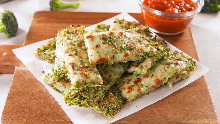 Broccoli Cheesy Bread on a white plate with a small bowl of sauce next to it. 
