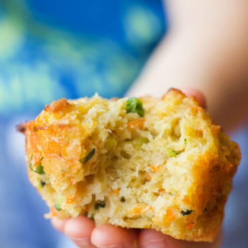 Image of a muffin with various vegetables in it and a bite taken out of it. 
