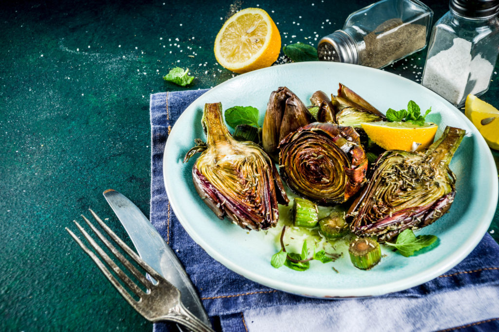 Cooked baked artichoke, alla romana, grilled artichoke flowers with olive oil, lemon, garlic, mint  and spices. Copy space