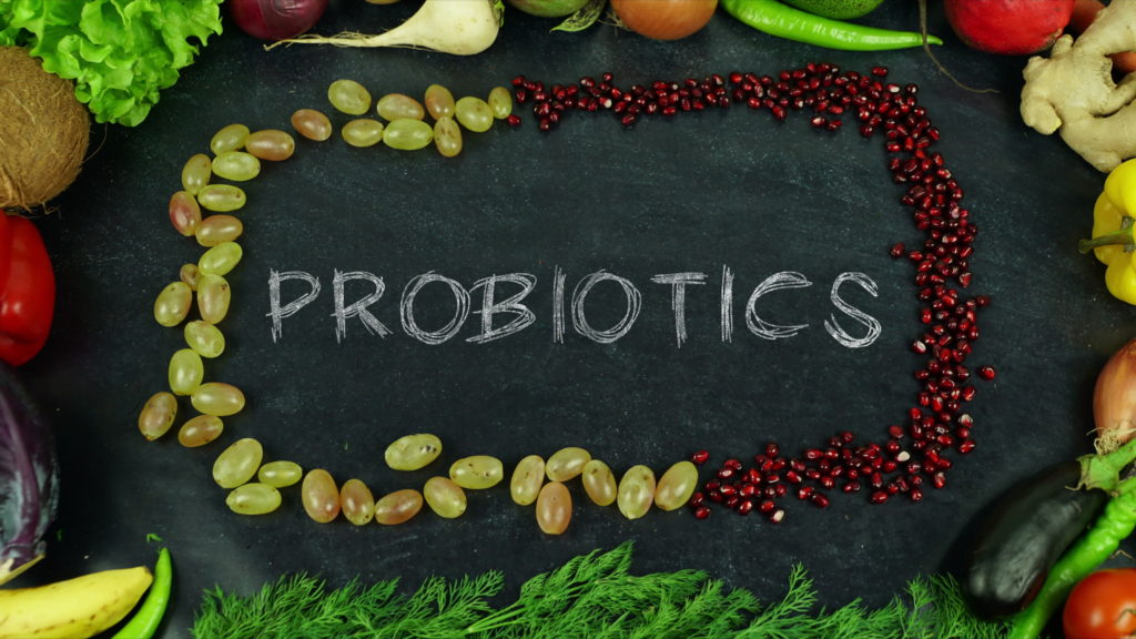 The word probiotics on a chalk board surrounded by Organic fruits and vegetables for all seasons and for healthy life