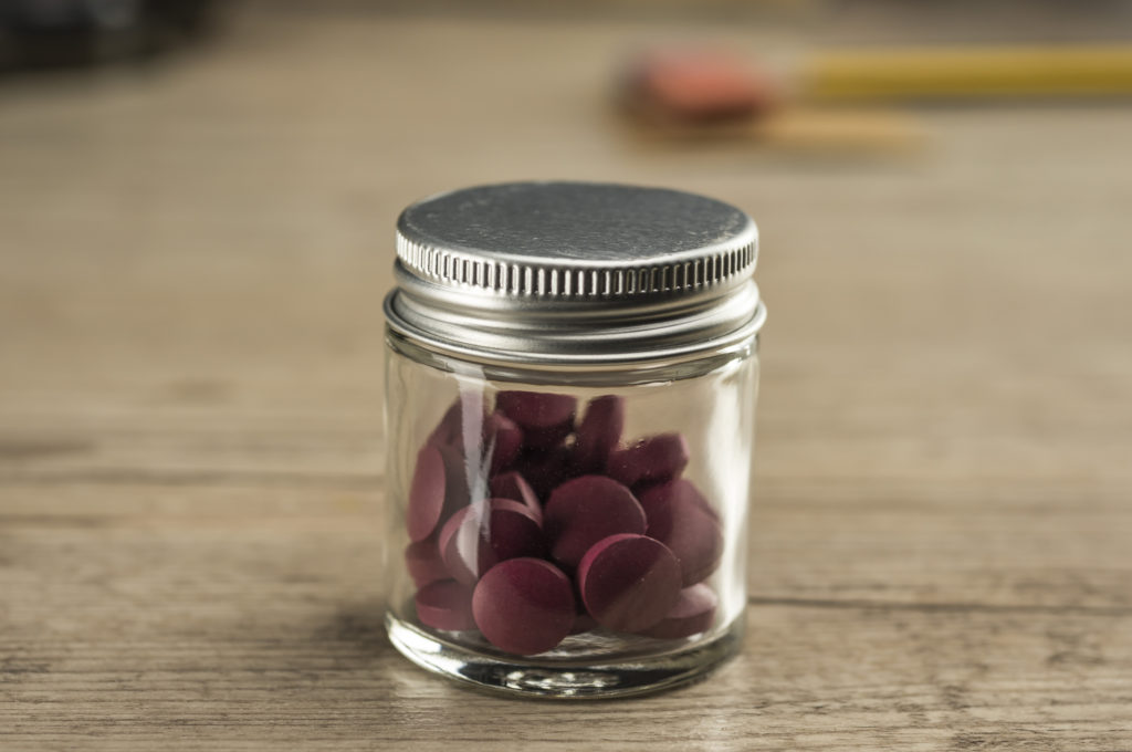 small glass jar with iron supplements/pills
