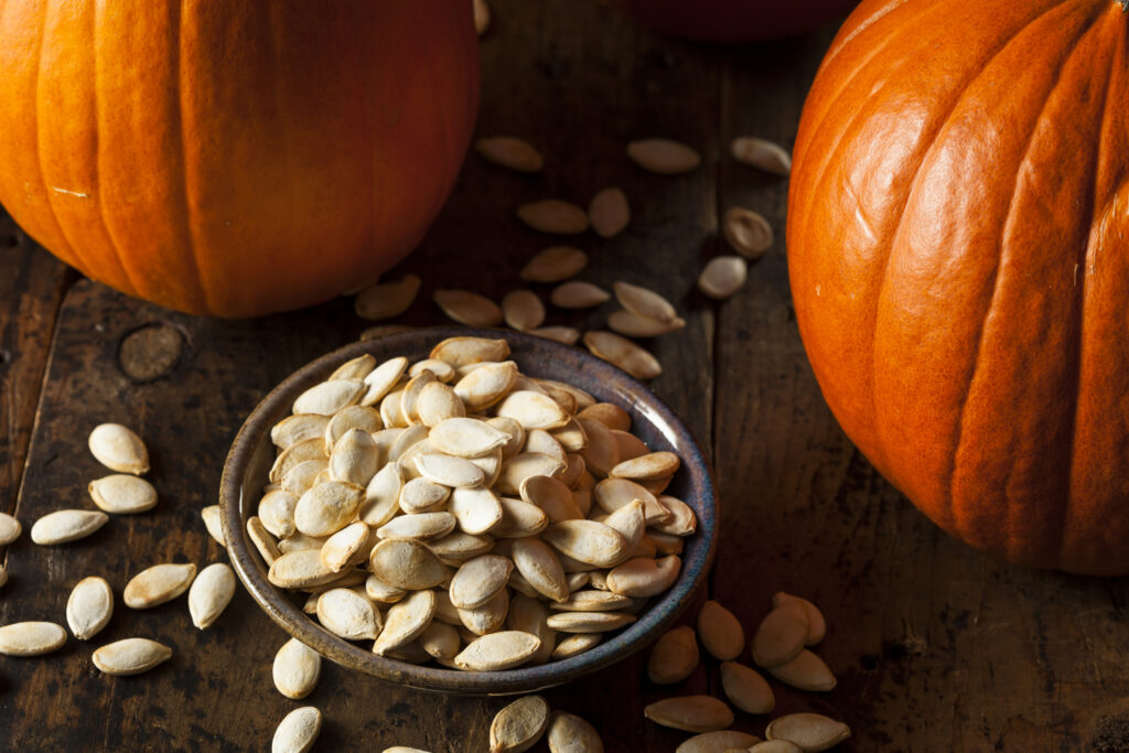 Pumpkins with a bowl of roasted pumpkin seeds