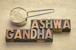 scoop of ashwagandha root (aka Indian ginseng) powder with a text in vintage letterpress wood type, superfood healthy supplement